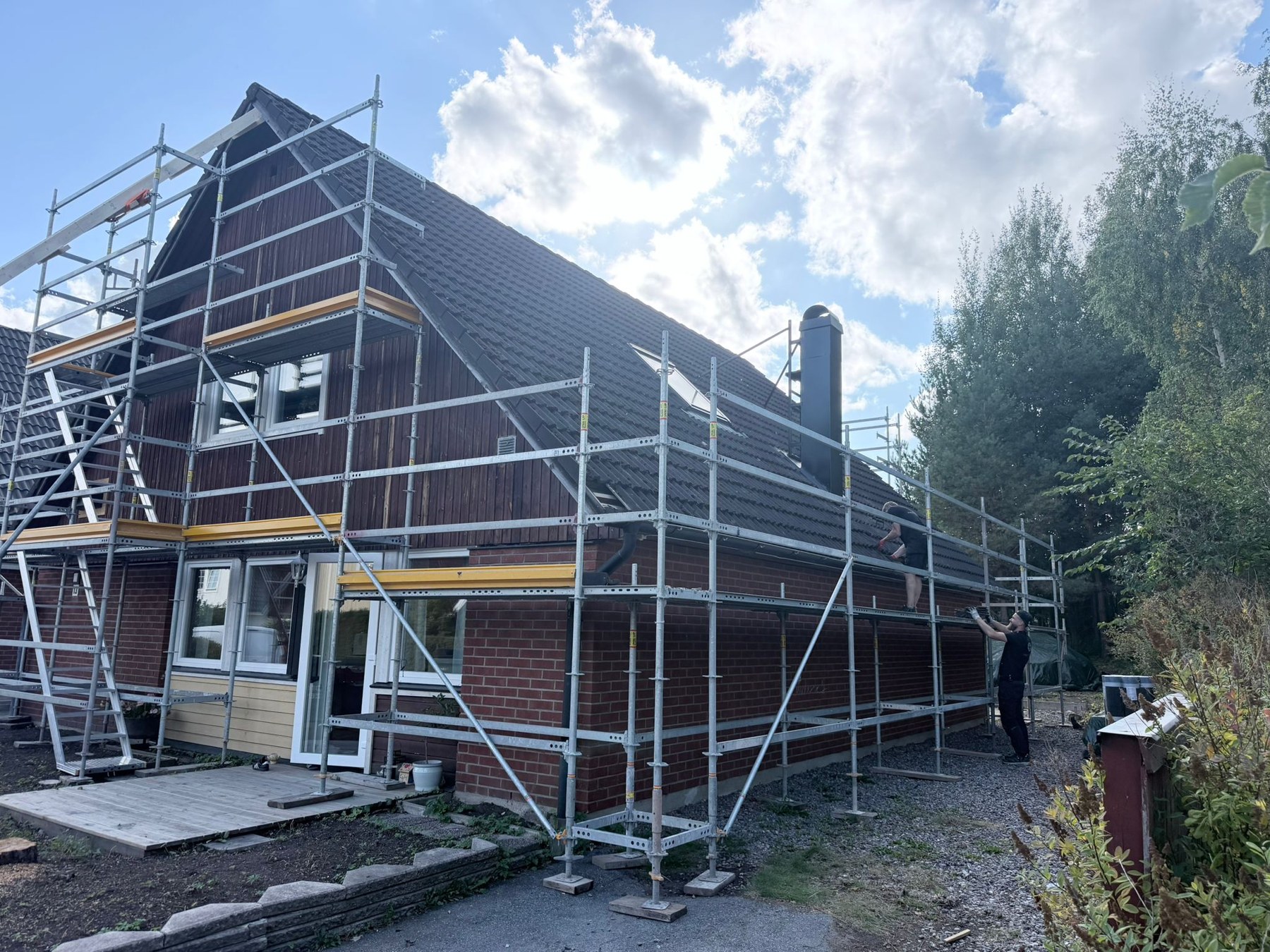 Villa med byggställning och det äldre takets slitna betongpannor